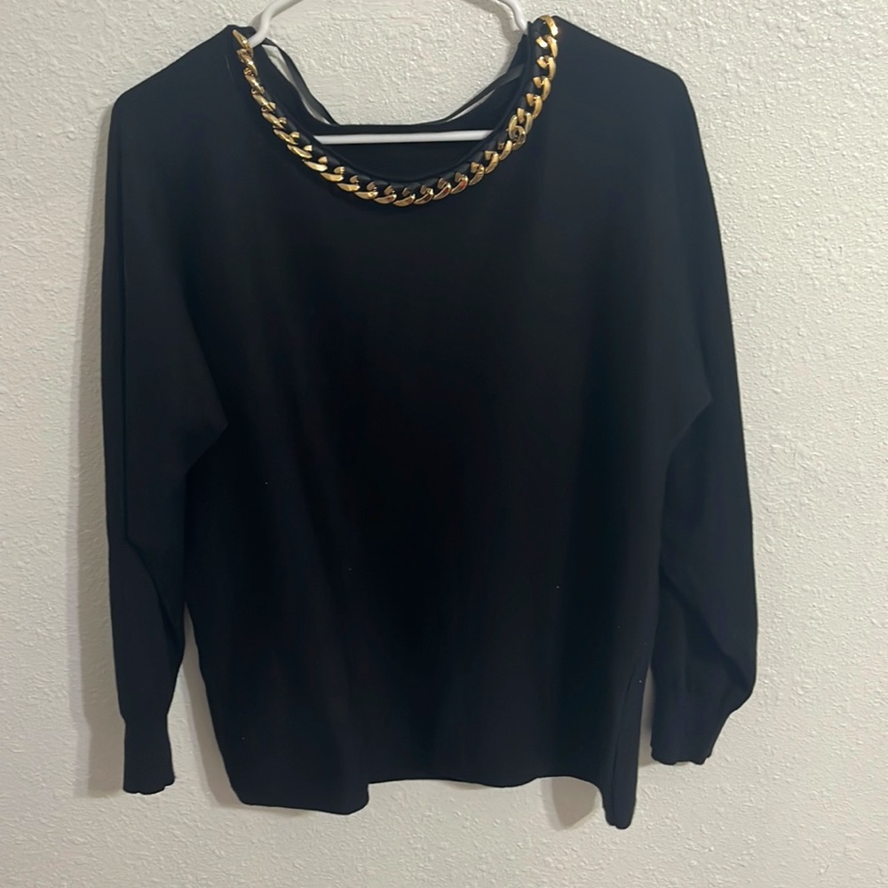 Black shirt with gold chain around neck. No rips, pet free/ smoke free home